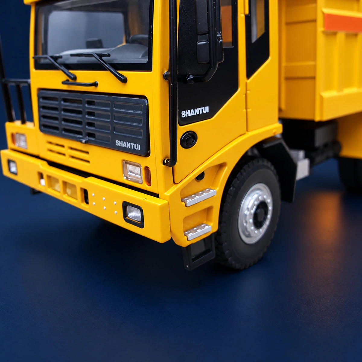 Close-up of the front grille, headlight elements, printed branding and cab access steps